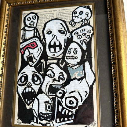 disturbing cartoon faces cluster on aged paper framed horror artwork
